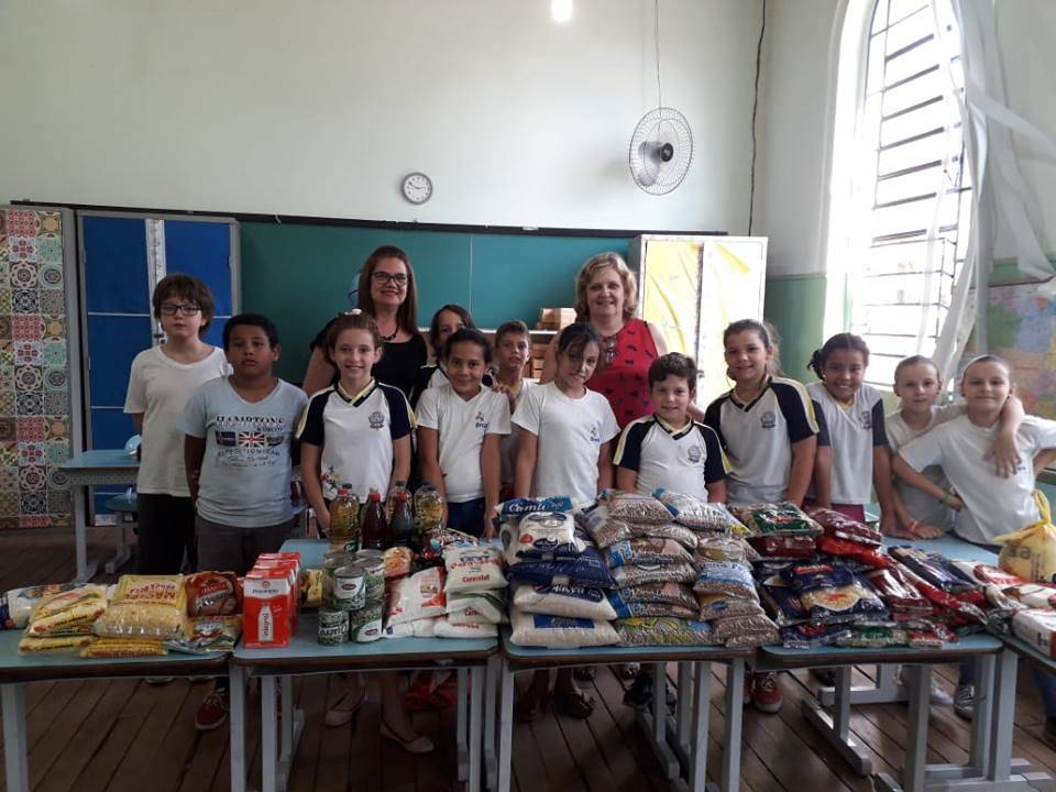 Em atividade de ensino da apostila, alunos da Escola Francisca fazem gesto de solidariedade