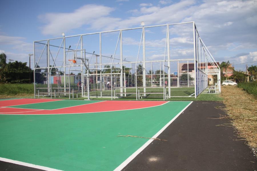 Pessoas jogando basquete em quadra poliesportiva pública na orla