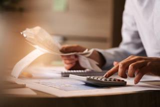 closeup-de-economista-usando-calculadora-ao-passar-por-contas-e-impostos-no-escritorio_637285-3156