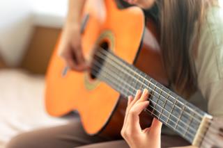 rapariga-toca-guitarra-classica-ou-acustica-guitarra-em-close-up