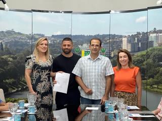 Entrega do termo de posse para a Volk Confecções